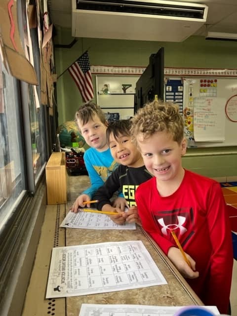 students smiling with worksheets